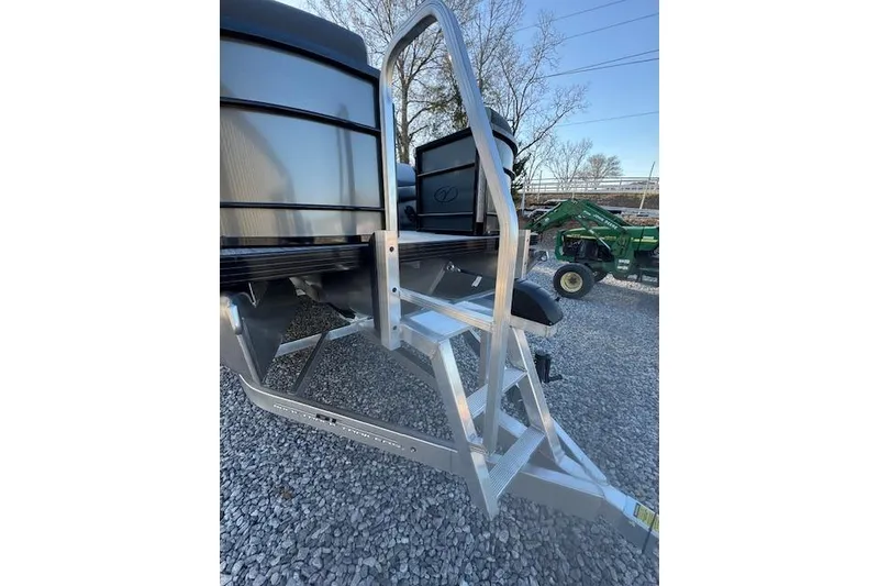 Slide: The Image of 2026 Veranda Relax VR 22 RC pontoon boat with aluminum ladder on gravel surface. - 13