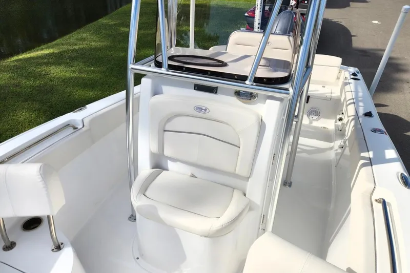 Slide: The Image of 2023 Sea Hunt Ultra 219 boat interior with white seating and chrome details. - 10
