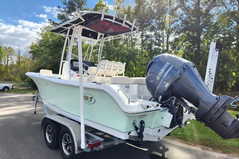 Slide: The Image of 2023 Sea Hunt Ultra 219 boat with Yamaha engine on trailer, parked outdoors. - 2