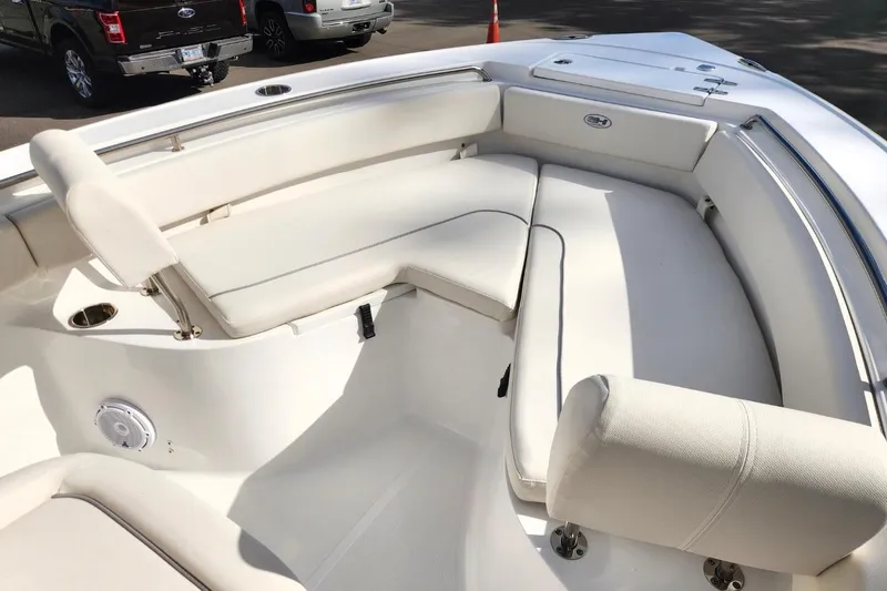 Slide: The Image of 2023 Sea Hunt Ultra 219 boat interior with white cushioned seating and modern design. - 8