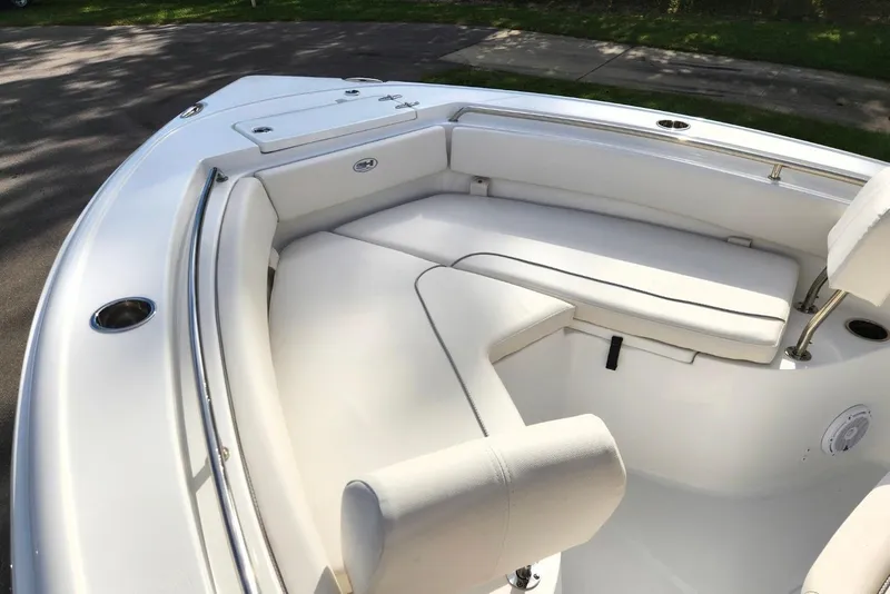 Slide: The Image of 2023 Sea Hunt Ultra 219 boat interior with white cushioned seating and stainless steel railings. - 9