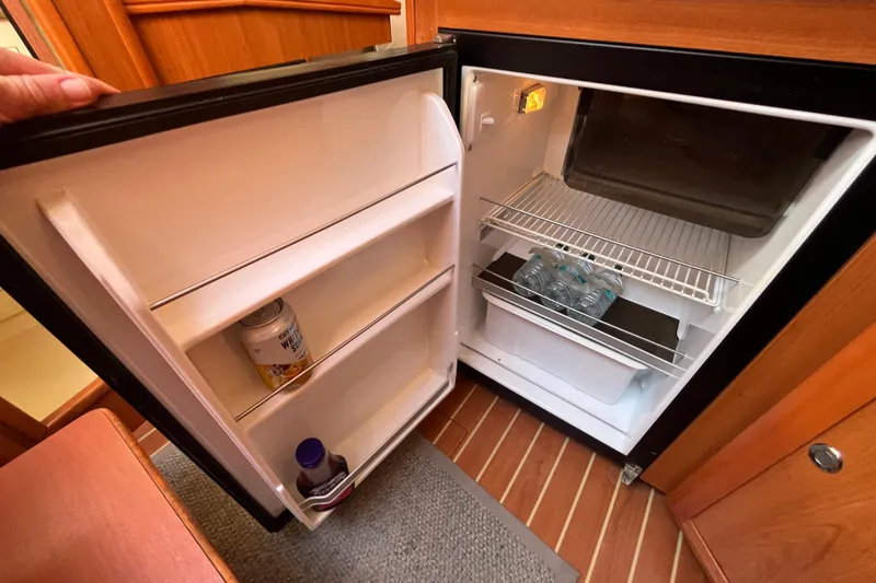 Slide: The Image of Open fridge inside 2008 Hunter 36 yacht, containing drinks and minimal items. - 31