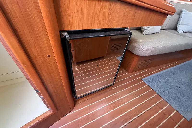 Slide: The Image of 2008 Hunter 36 yacht interior with wooden cabinetry and compact fridge. - 32