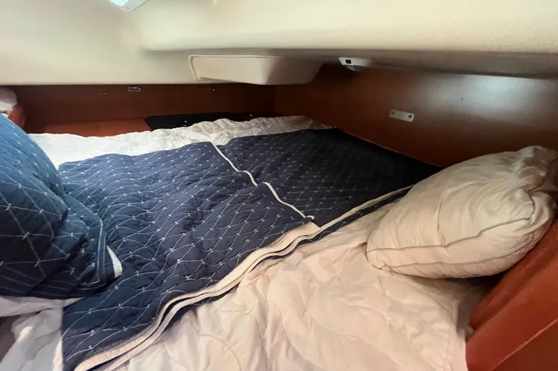 Slide: The Image of Cozy cabin bed in 2008 Hunter 36 sailboat with blue and white bedding. - 38