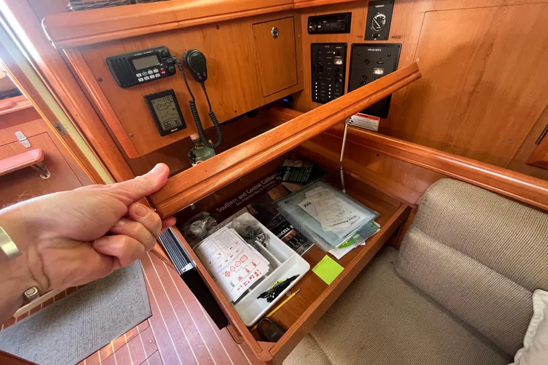 Slide: The Image of 2008 Hunter 36 sailboat navigation station with radio, controls, and storage compartment. - 42