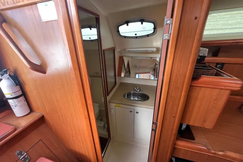 Slide: The Image of Interior of 2008 Hunter 36 sailboat showing bathroom with sink and wooden cabinetry. - 45
