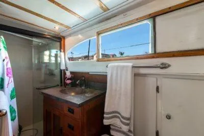 Slide: The Image of 1950 Monk Pilothouse bathroom with wooden vanity, towel rack, and window view. - 10