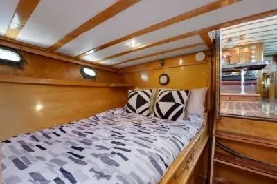 Slide: The Image of 1950 Monk Pilothouse interior with cozy wooden cabin and patterned bedding. - 14
