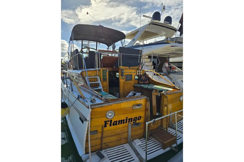 Slide: The Image of 1950 Monk Pilothouse boat "Flamingo" docked, featuring wooden details and canopy. - 16