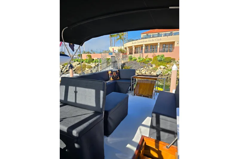 Slide: The Image of 1950 Monk Pilothouse boat interior with seating, docked near Pacific Corinthian Yacht Club. - 17