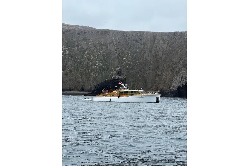 Slide: The Image of 1950 Monk Pilothouse boat on water near rocky cliffs. - 19