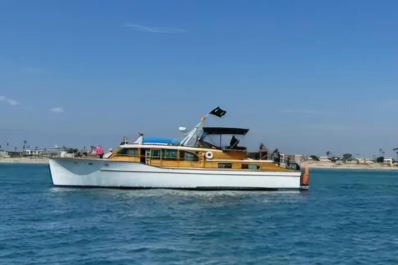 Slide: The Image of 1950 Monk Pilothouse boat cruising on calm blue waters under clear skies. - 21