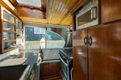 Slide: The Image of 1950 Monk Pilothouse kitchen with wood cabinetry and modern appliances. - 4