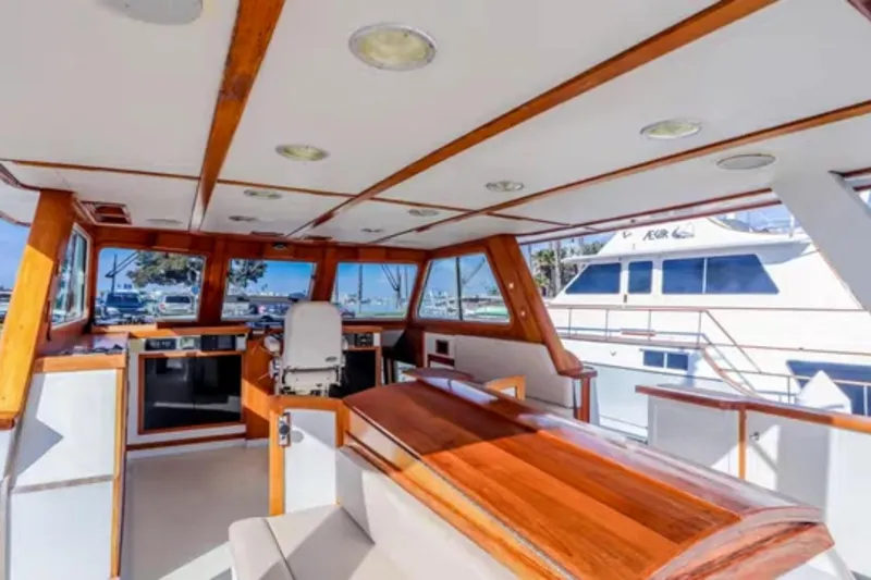 Slide: The Image of 1969 Islander 72 Aft Cabin Motor Yacht interior with wood accents and panoramic windows. - 10