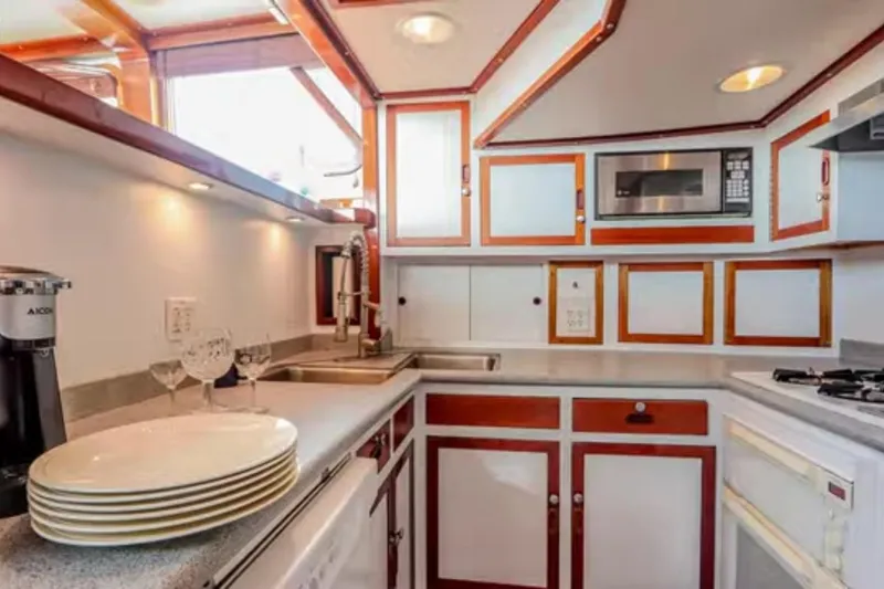 Slide: The Image of 1969 Islander 72 Aft Cabin Motor Yacht kitchen with modern appliances and elegant cabinetry. - 13