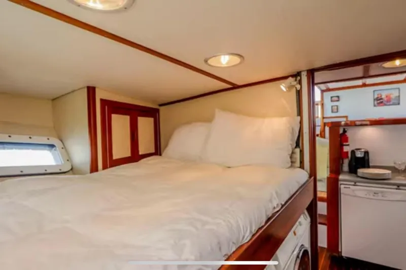 Slide: The Image of Cozy cabin interior of 1969 Islander 72 Aft Cabin Motor Yacht with bed and kitchenette. - 14