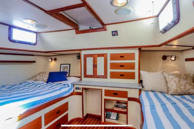 Slide: The Image of 1969 Islander 72 Aft Cabin Motor Yacht interior with twin beds and wooden cabinetry. - 17