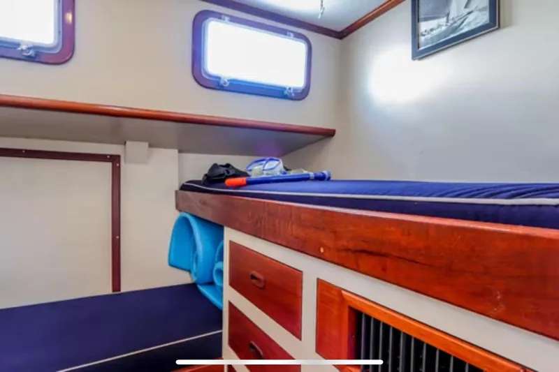 Slide: The Image of Interior cabin of 1969 Islander 72 Aft Cabin Motor Yacht with wooden accents and storage. - 19