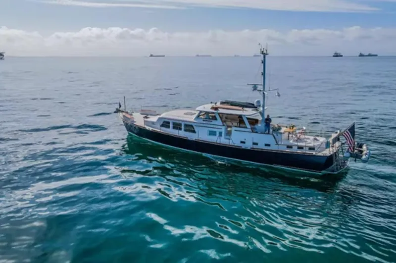 Slide: The Image of 1969 Islander 72 Aft Cabin Motor Yacht cruising on open sea under clear skies. - 3