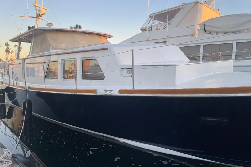 Slide: The Image of 1969 Islander 72 Aft Cabin Motor Yacht docked at sunset, featuring classic design. - 5