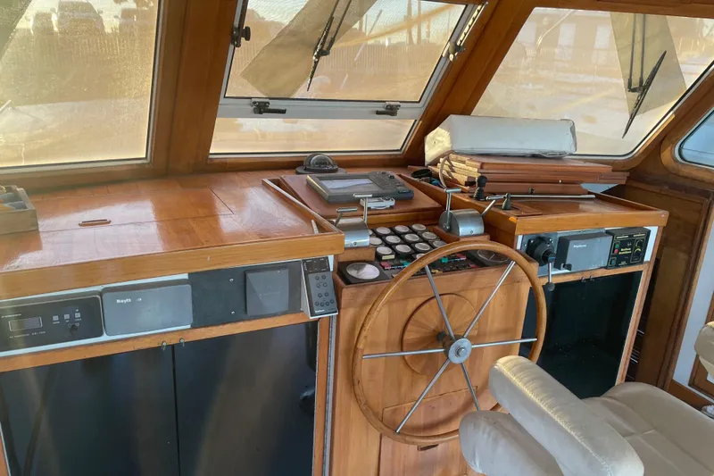 Slide: The Image of 1969 Islander 72 Aft Cabin Motor Yacht helm with wooden steering wheel and navigation equipment. - 7