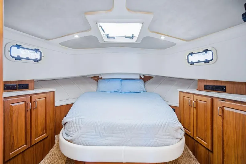 Slide: The Image of Cozy cabin interior of 1998 Mainship 350 Trawler with bed and wooden cabinets. - 18