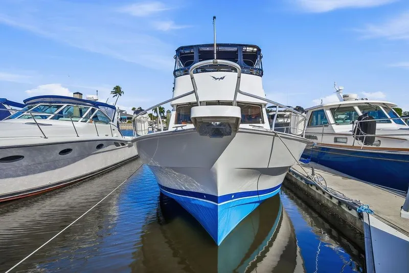Slide: The Image of 1998 Mainship 350 Trawler docked between two boats in a marina. - 2