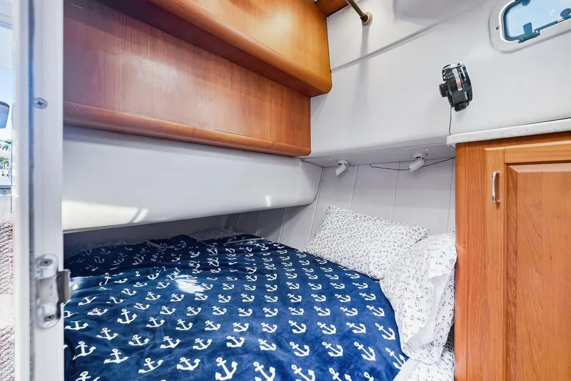 Slide: The Image of Cozy cabin interior of 1998 Mainship 350 Trawler with nautical-themed bedding. - 20