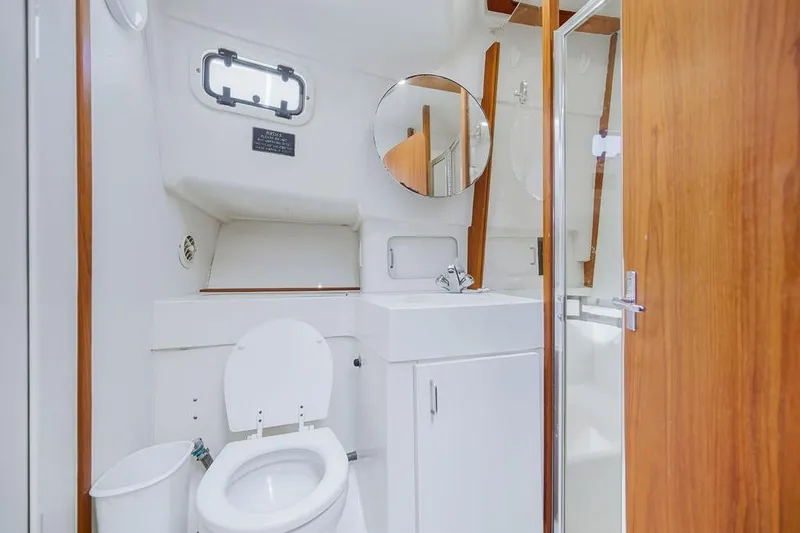 Slide: The Image of 1998 Mainship 350 Trawler bathroom with toilet, sink, and shower. - 21
