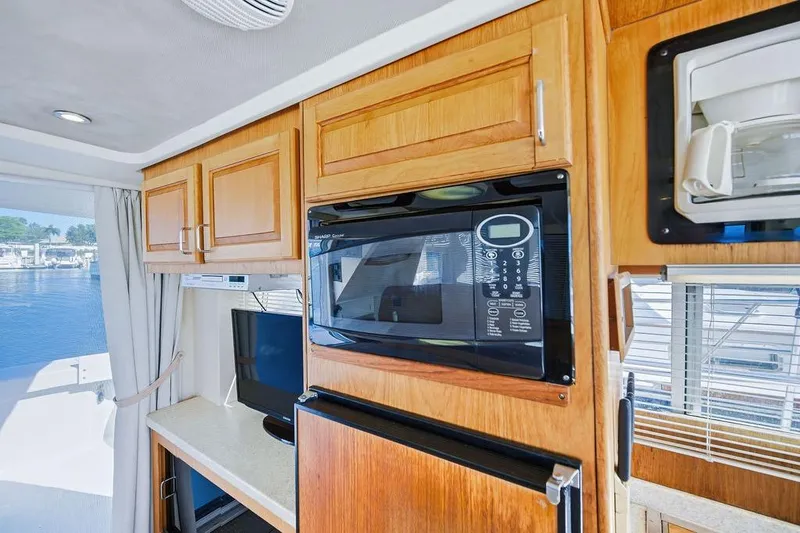 Slide: The Image of Interior of 1998 Mainship 350 Trawler with microwave, TV, and wooden cabinetry. - 25