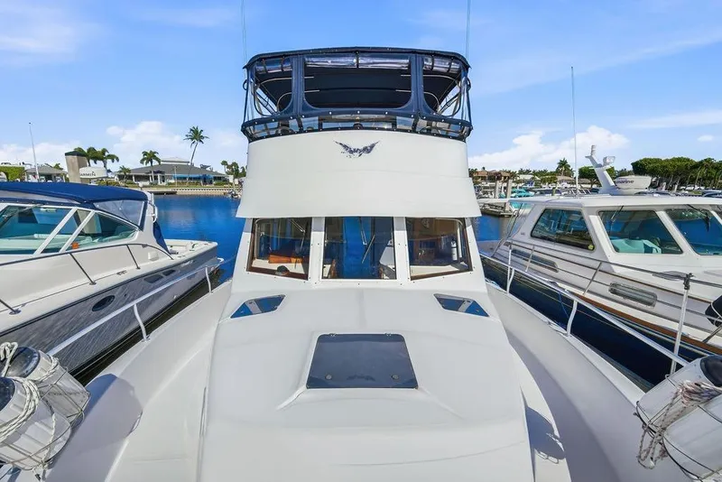 Slide: The Image of 1998 Mainship 350 Trawler docked at marina, surrounded by other boats, under clear blue sky. - 3
