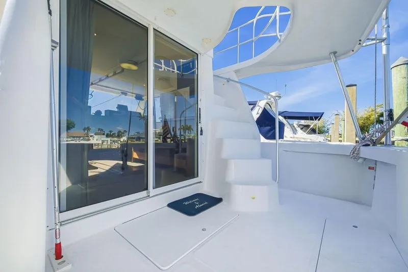 Slide: The Image of 1998 Mainship 350 Trawler with white deck, spiral staircase, and sliding glass doors. - 8