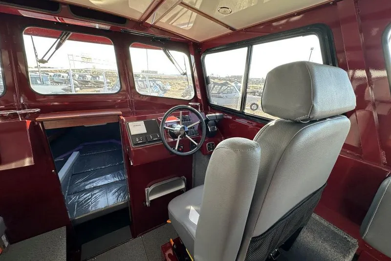 Slide: The Image of Interior of 2026 Hewescraft 270 Pacific Explorer boat, featuring steering wheel and seating. - 8