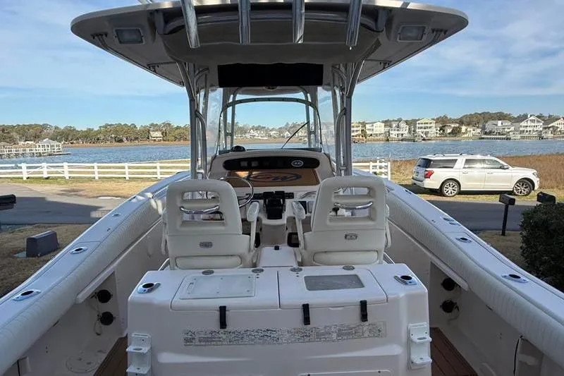 Slide: The Image of 2007 Grady-White Bimini 306 boat docked near waterfront homes and parked SUV. - 10