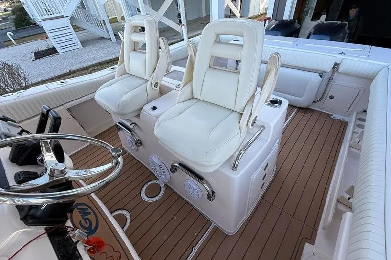 Slide: The Image of 2007 Grady-White Bimini 306 boat interior with white seating and wooden deck. - 17