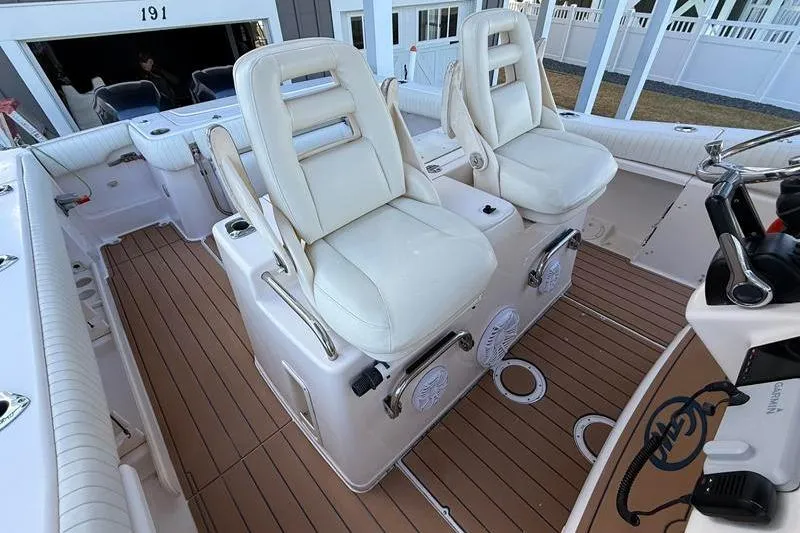 Slide: The Image of 2007 Grady-White Bimini 306 boat interior with white seats and teak flooring. - 18