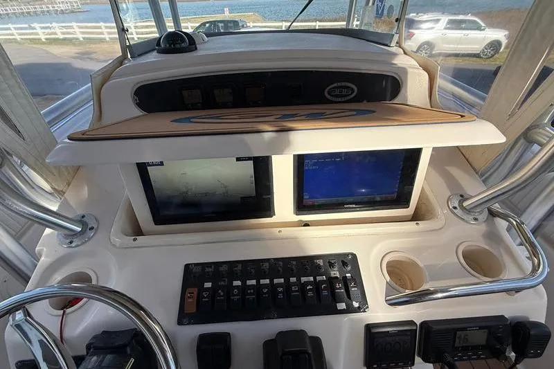 Slide: The Image of 2007 Grady-White Bimini 306 boat dashboard with dual screens and control panel. - 19