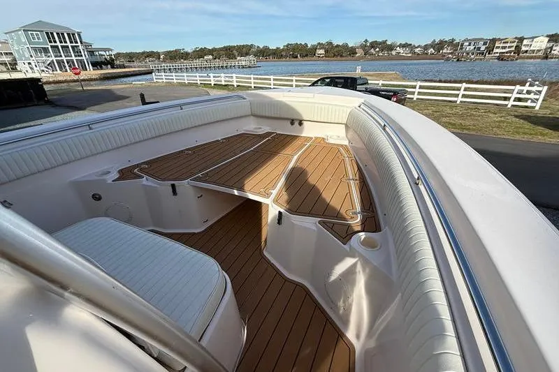 Slide: The Image of 2007 Grady-White Bimini 306 boat with spacious deck and seating, near waterfront homes. - 28