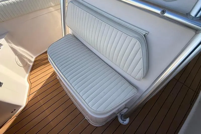 Slide: The Image of 2007 Grady-White Bimini 306 boat seat with white upholstery and wooden deck. - 33