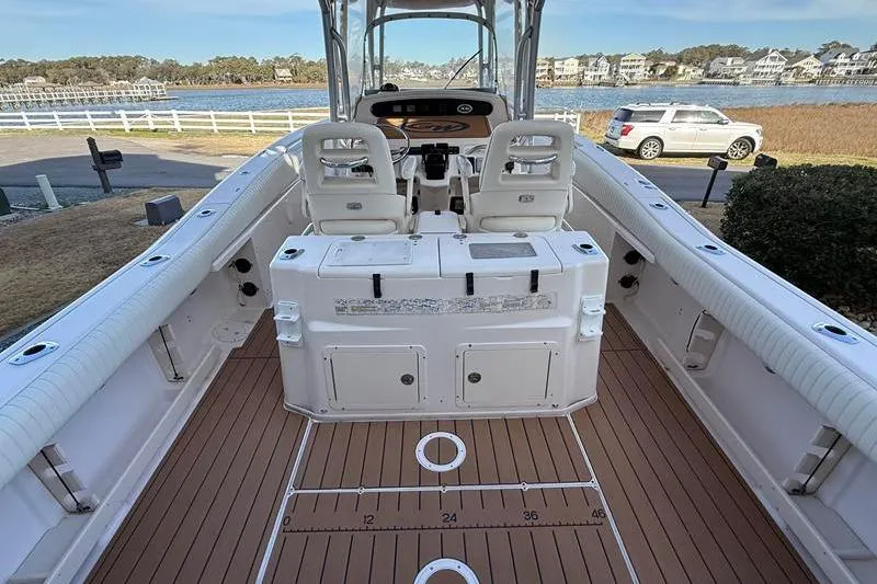 Slide: The Image of 2007 Grady-White Bimini 306 boat interior with seating and console, docked near waterfront homes. - 9
