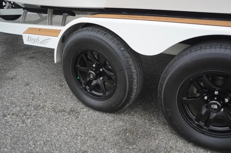 Slide: The Image of Trailer wheels of a 2022 Tigé 22RZX boat on pavement. - 10