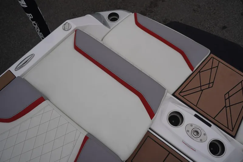 Slide: The Image of 2022 Tigé 22RZX boat interior with white, gray, and red seating, and cup holders. - 23
