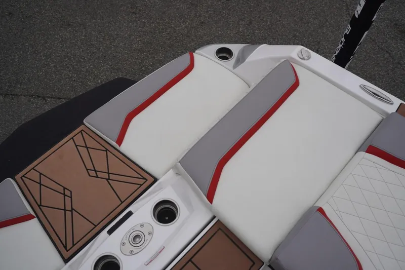 Slide: The Image of 2022 Tigé 22RZX boat interior with white, gray, and red seating, and cup holders. - 24