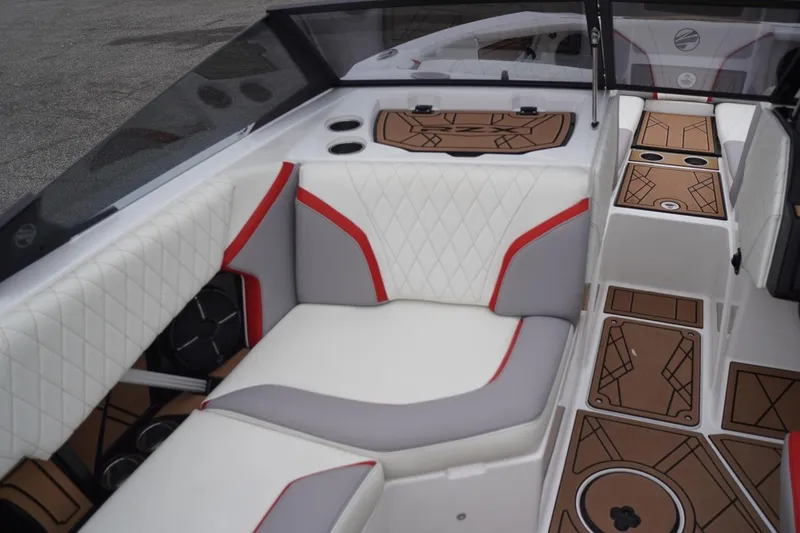 Slide: The Image of 2022 Tigé 22RZX boat interior with white and red seating, brown flooring. - 28