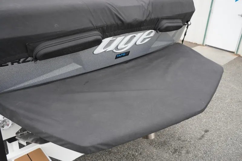 Slide: The Image of 2022 Tigé 22RZX boat with covered swim platform and logo detail. - 3