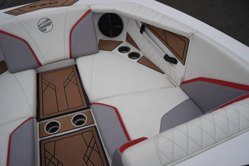 Slide: The Image of 2022 Tigé 22RZX boat interior with white, gray, and red upholstery, featuring cup holders. - 35