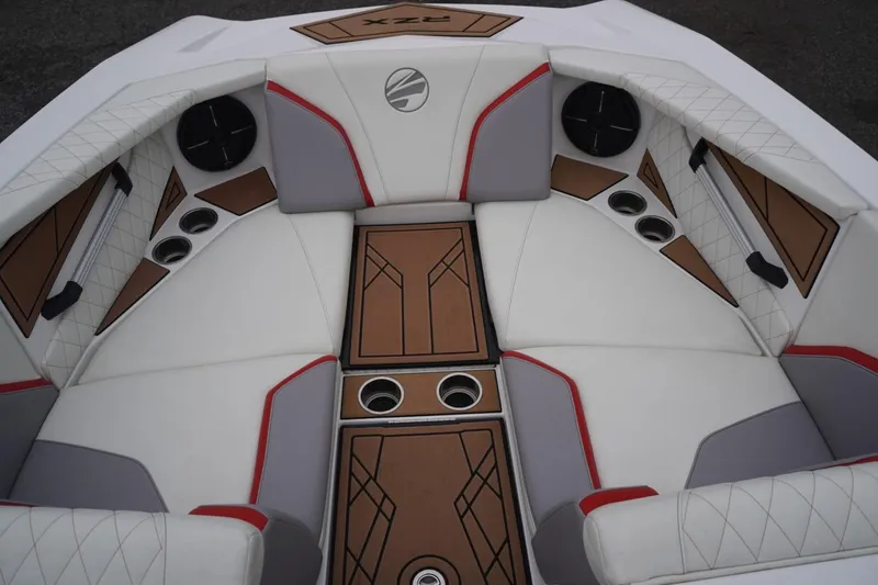 Slide: The Image of 2022 Tigé 22RZX boat interior with white and gray seating, red accents, and cup holders. - 36