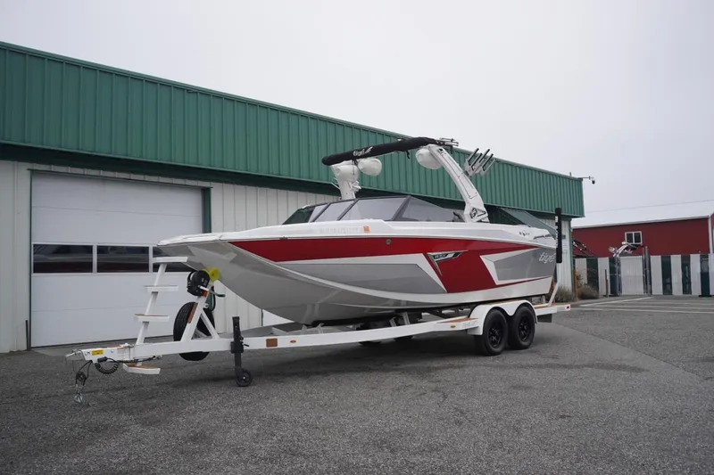 Slide: The Image of 2022 Tigé 22RZX boat on trailer, parked outside a green building. - 4
