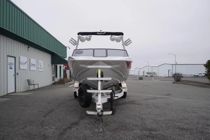 Slide: The Image of 2022 Tigé 22RZX boat on trailer outside dealership, overcast day. - 5