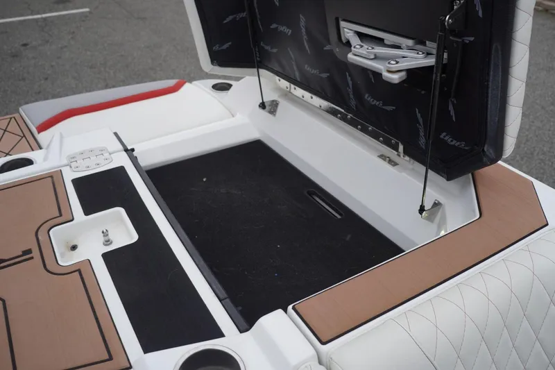 Slide: The Image of 2022 Tigé 22RZX boat storage compartment with open hatch and cushioned seating. - 58